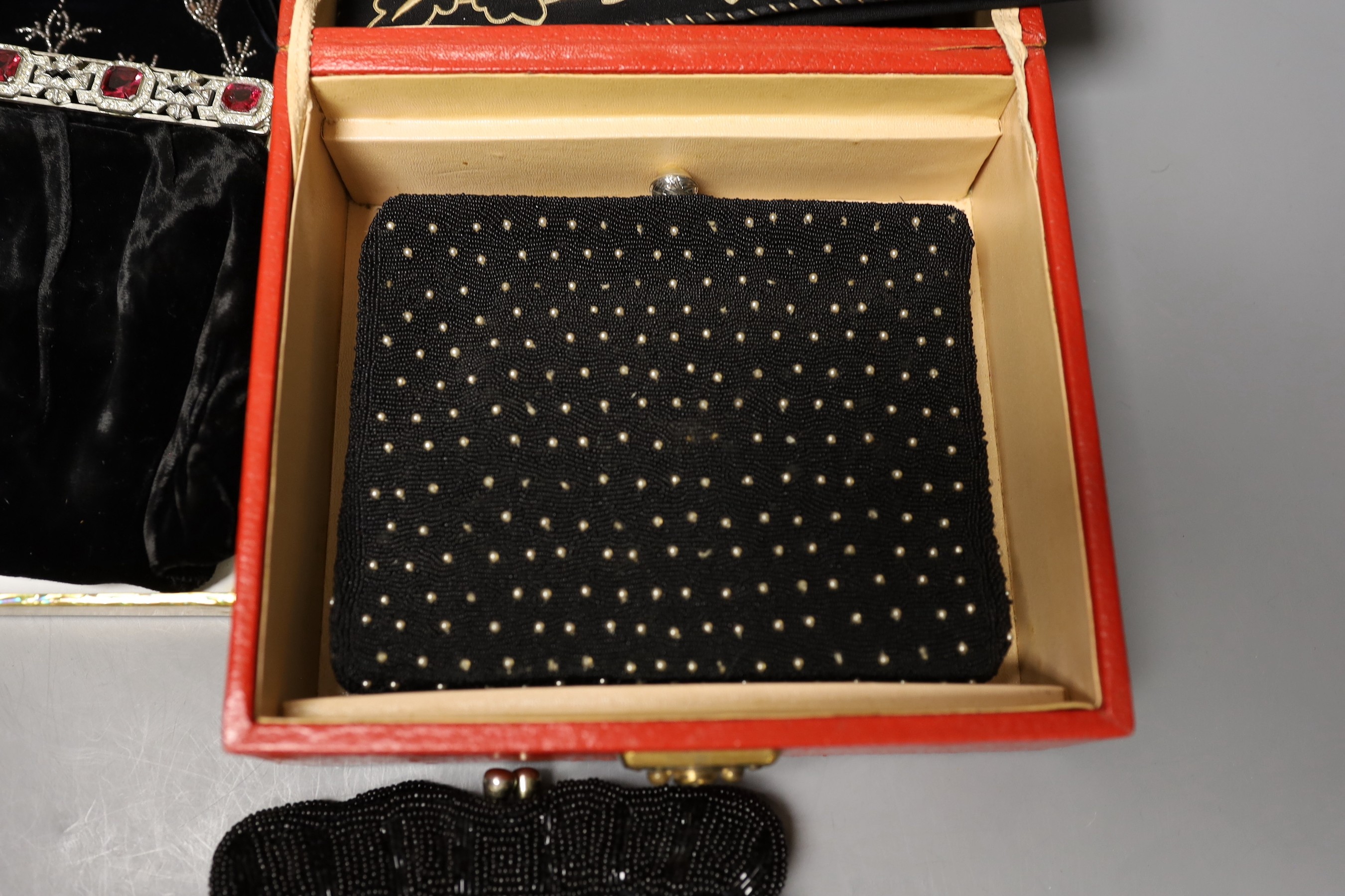 A 19th century cut steel, black velvet bag, a 1940’s-50’s diamanté handled clutch bag, 1930’s embroidered clutch bag, together with four later black beaded evening bags